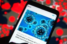  Thông báo của Tổ chức Y tế Thế giới về biến thể Omicron, trên một màn hình điện thoại thông minh. (Ảnh: Getty Images/TTXVN)