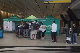 Hành khách xếp hàng chờ xét nghiệm COVID-19 tại sân bay ở Johannesburg, Nam Phi, ngày 27/11/2021. (Ảnh: AFP/TTXVN)