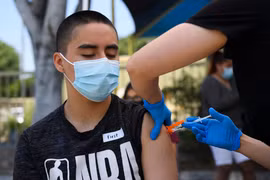 Tiêm vaccine ngừa COVID-19 cho học sinh tại Los Angeles, California, Mỹ. (Ảnh: AFP/TTXVN)