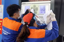 Nhân viên cửa hàng xăng dầu điều chỉnh giá bán. (Ảnh: Trần Việt/TTXVN)