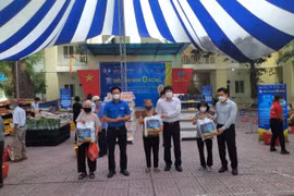 Lãnh đạo UBND quận Đống Đa cùng nhà hảo tâm trao quà "Siêu thị mini 0 đồng" cho người dân gặp khó khăn do dịch COVID-19. (Ảnh TTXVN phát)