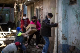 Tình nguyện viên phân phát lương thực cứu trợ do dịch COVID-19 cho người dân tại Buenos Aires, Argentina, ngày 25/7/2020. (Ảnh: AFP/TTXVN)
