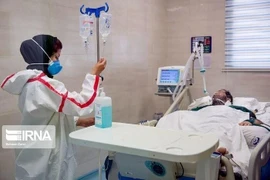 Nhân viên y tế điều trị cho bệnh nhân COVID-19 tại bệnh viện ở Iran. (Ảnh: IRNA/TTXVN)