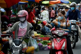 Người dân đeo khẩu trang phòng lây nhiễm COVID-19 tại Phnom Penh, Campuchia. (Ảnh: AFP/TTXVN)
