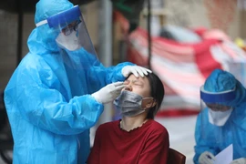 Nhân viên y tế quận Hoàn Kiếm lấy mẫu xét nghiệm COVID-19 cho các trường hợp có nguy cơ cao. (Ảnh: Minh Quyết/TTXVN)