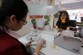 Khách hàng giao dịch tại NHTMCP nhà Thành phố Hồ Chí Minh (HD Bank) chi nhánh Hà Nội. (Ảnh: Trần Việt/TTXVN)