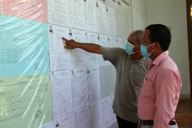 Cử tri xã Phước Trung, huyện Bác Ái tìm hiểu tiểu sử của các ứng cử viên đại biểu Quốc hội và HĐND các cấp tại tổ bầu cử số 5 ở địa phương. (Ảnh: Công Thử/TTXVN)