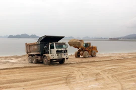 Công ty Phương Đông huy động phương tiện khắc phục hậu quả sai phạm, hoàn nguyên hiện trạng ban đầu. (Ảnh: Văn Đức/TTXVN)