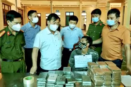 Phó Chủ tịch UBND tỉnh Điện Biên Vừ A Bằng, (áo trắng giữa), cùng Phó Giám đốc Công an tỉnh Điện Biên trực tiếp hỏi cung đối tượng Lầu A Di bị bắt trong chuyên án 621D. (Ảnh: TTXVN phát)