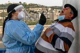 Nhân viên y tế Israel lấy mẫu xét nghiệm COVID-19 cho người dân tại Jerusalem ngày 14/12/2020. (Ảnh: AFP/TTXVN)