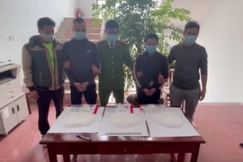 Hai đối tượng cùng tang vật tại cơ quan công an. (Ảnh: Đinh Tuấn/TTXVN)