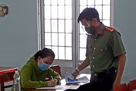 Lực lượng chức năng Vĩnh Long làm việc với đối tượng Lê Kim Liên về hành vi đăng tin sai sự thật. Ảnh do cơ quan công an cung cấp. (Nguồn: thanhnien.vn)