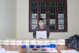 Đối tượng Sùng A Bia cùng tang vật vụ án. (Ảnh: TTXVN phát)