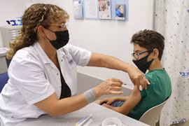Nhân viên y tế tiêm vaccine ngừa COVID-19 của hãng Pfizer-BioNTech cho trẻ 12 tuổi tại Tel Aviv, Israel ngày 6/6/2021. (Ảnh: AFP/TTXVN)