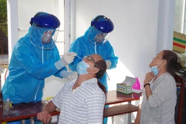 Cán bộ Trung tâm kiểm soát bệnh tật tỉnh Bạc Liêu lấy mẫu bệnh phẩm xét nghiệm sàng lọc bệnh COVID-19. (Ảnh: Chanh Đa/TXVN)