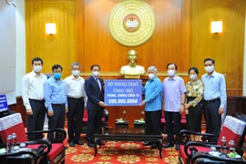 Chủ tịch Ủy ban Trung ương Mặt trận Tổ quốc Việt Nam Đỗ Văn Chiến tiếp nhận tượng trưng số tiền 500 triệu đồng từ Bộ trưởng Bộ Ngoại giao Bùi Thanh Sơn. (Ảnh: Minh Đức/TTXVN)