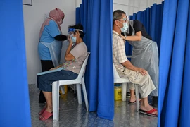 Nhân viên y tế tiêm vacicne phòng COVID-19 cho người dân tại Kuala Lumpur, Malaysia, ngày 21/6/2021. (Ảnh: AFP/TTXVN)