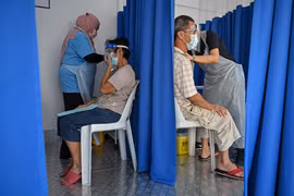 Nhân viên y tế tiêm vacicne phòng COVID-19 cho người dân tại Kuala Lumpur, Malaysia, ngày 21/6/2021. (Ảnh: AFP/TTXVN)