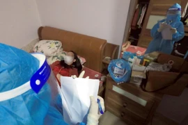 Nhân viên y tế đến kiểm tra sức khỏe và phát thuốc cho trường hợp F0 đang điều trị tại nhà tại Xóm 2, xã Tam Hiệp, huyện Thanh Trì. (Ảnh: Tuấn Anh/TTXVN)
