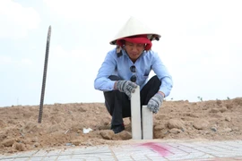 Cắm mốc nhằm xác định vị trí, diện tích các lô đất tại Khu tái định cư Lộc An-Bình Sơn. (Ảnh: Công Phong/TTXVN)
