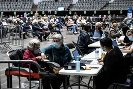 Người dân đăng ký thông tin tại điểm tiêm vaccine phòng COVID-19 ở Lyon, Pháp. (Ảnh: AFP/TTXVN)