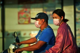 Người dân đeo khẩu trang di chuyển trên đường phố Bangkok, Thái Lan. (Ảnh: THX/TTXVN)