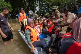 Lực lượng cứu hộ sơ tán người dân khỏi vùng ngập lụt sau những trận mưa lớn tại Shah Alam, Selangor, Malaysia, ngày 20/12/2021. (Ảnh: THX/TTXVN)
