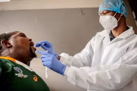 Nhân viên y tế lấy mẫu dịch xét nghiệm COVID-19 cho người dân tại Richmond, Johannesburg, Nam Phi. (Ảnh: AFP/ TTXVN)