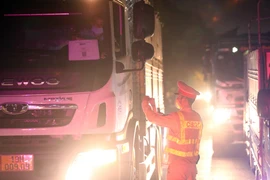 Lực lượng CSGT kiểm tra giấy tờ các phương tiện giao thông đăng ký luồng xanh trước khi di chuyển vào Hà Nội. (Ảnh: Phạm Kiên/TTXVN)