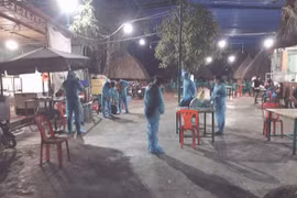 Nhân viên y tế thuộc Trung tâm kiểm soát bệnh tật tỉnh Bình Phước và Trung tâm Y tế TP Đồng Xoài đến quán lẩu dê Vườn Xoài truy vết, lấy thông tin những người liên quan tối 6/2. (Nguồn: tuoitre.vn)