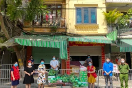 Điểm phát hàng miễn phí nhu yếu phẩm cho người lao động nghèo, người yếu thế. (Ảnh TTXVN phát)