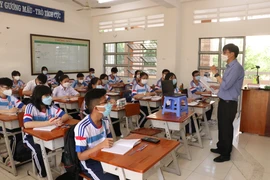 Giáo viên trên lớp mở laptop để học sinh F0, F1 đang cách ly tại nhà có thể cùng học với các bạn ở lớp. (Ảnh: Đức Hạnh/TTXVN)