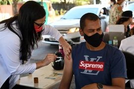 Nhân viên y tế tiêm vaccine phòng COVID-19 cho người dân tại Brasilia, Brazil ngày 13/9/2021. (Ảnh: AFP/TTXVN)