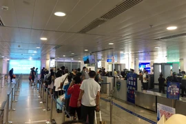 Hành khách làm thủ tục tại sân bay Tân Sơn Nhất. (Ảnh: Tiến Lực/TTXVN)