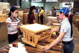 Sản xuất đồ gỗ nội thất xuất khẩu tại nhà máy ở huyện Đông Anh (Hà Nội). (Ảnh: TTXVN)