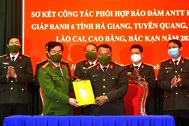 Lãnh đạo Công an tỉnh Hà Giang bàn giao đơn vị thường trực năm 2022 cho lãnh đạo Công an tỉnh Tuyên Quang. (Ảnh: Kim Tiến/TTXVN)