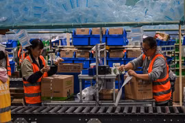 Nhân viên làm việc tại một kho hàng của Alibaba tại tỉnh Giang Tô, Trung Quốc. (Ảnh: AFP/TTXVN)