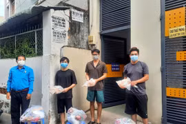 Đại diện Liên đoàn Lao động Thành phố Hồ Chí Minh trao quà cho công nhân lao động gặp khó khăn đang ở trọ tại phường Bình Thọ, thành phố Thủ Đức. (Ảnh: Thanh Vũ/TTXVN)