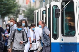 Người dân đeo khẩu trang phòng dịch COVID-19 khi sử dụng phương tiện lưu thông công cộng tại Zurich, Thụy Sĩ. (Ảnh: Reuters/TTXVN)