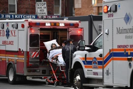 Nhân viên y tế chuyển bệnh nhân COVID-19 tới bệnh viện tại New York, Mỹ. (Ảnh: AFP/TTXVN)