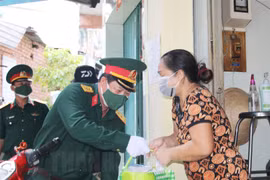Cán bộ, chiến sỹ Trung đoàn Gia Định và các nhà hảo tâm trao quà cho người dân khó khăn quận 8. (Nguồn: hcmcpv.org.vn)