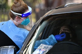 Nhân viên y tế lấy mẫu xét nghiệm COVID-19 cho người dân tại một điểm xét nghiệm di động ở Sydney, Australia. (Ảnh: AFP/TTXVN)