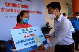  Lãnh đạo Quận ủy quận Tân Phú trao sổ bảo hiểm cho đoàn viên nghiệp đoàn có hoàn cảnh khó khăn ở quận Tân Phú. (Ảnh: Thanh Vũ/TTXVN)