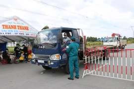 Lực lượng chức năng làm nhiệm vụ tại chốt kiểm soát trên đường Lý Thường Kiệt, phường Định Hòa, thành phố Thủ Dầu Một, tỉnh Bình Dương. (Ảnh: Chí Tưởng/TTXVN)