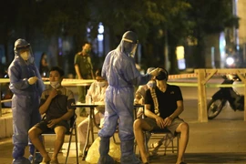 Lực lượng y tế lấy mẫu xét nghiệm đối với những người có liên quan đến ca nghi nhiễm COVID-19 tại số 307 phố Trần Đại Nghĩa, Hà Nội. (Ảnh: Hoàng Hiếu/TTXVN)