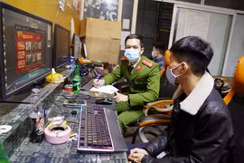 Công an lập biên bản các thanh niên chơi game vi phạm quy định phòng chống dịch COVID-19. (Ảnh: TTXVN phát)