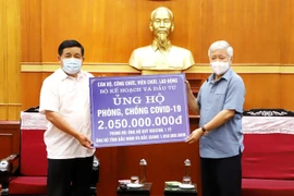 Chủ tịch Ủy ban Trung ương Mặt trận Tổ quốc Việt Nam Đỗ Văn Chiến tiếp nhận ủng hộ Quỹ vaccine phòng COVID-19 từ Bộ trưởng Bộ Kế hoạch và Đầu tư Nguyễn Chí Dũng. (Ảnh: Minh Đức/TTXVN)