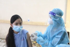 Tiêm vaccine phòng COVID-19 cho học sinh lớp 7 Trường THCS Trần Quốc Tuấn (thành phố Trà Vinh). (Ảnh: Thanh Hòa/TTXVN)