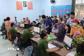 Lực lượng công an làm thủ tục cấp căn cước cho người dân. (Ảnh: TTXVN)
