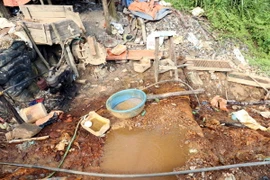 Các đối tượng đãi vàng gây ô nhiễm nguồn nước. (Ảnh: Nhóm phóng viên TTXVN)